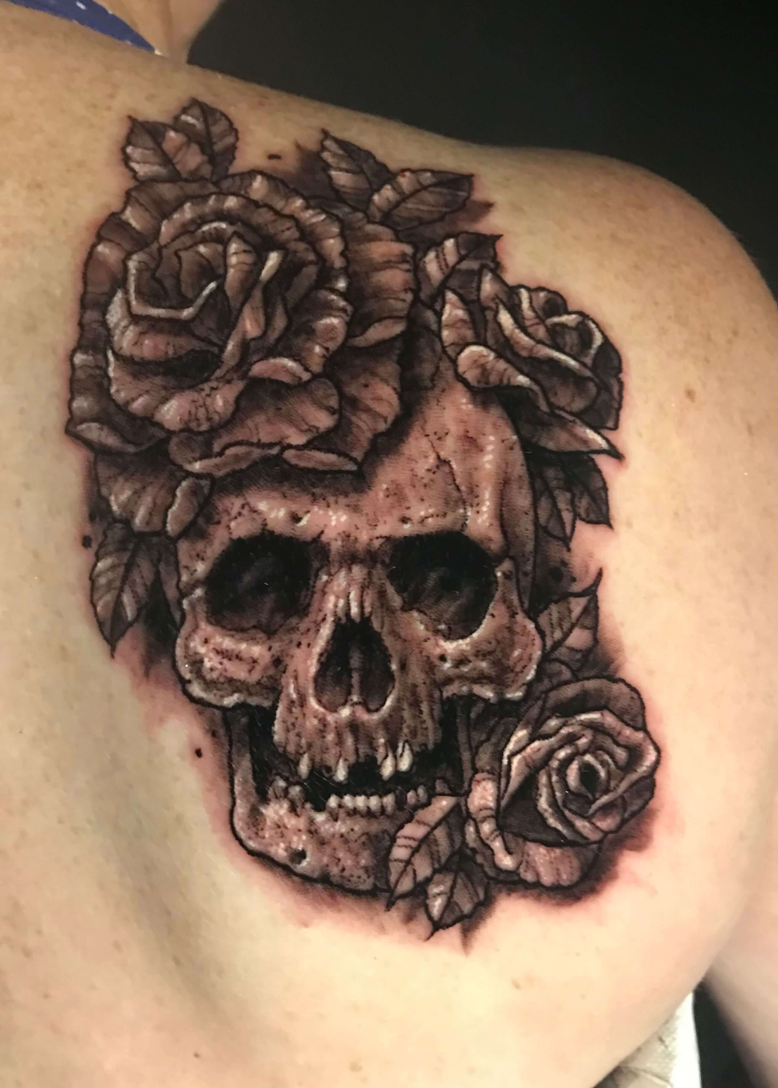 Tatuaje en la espalda de una calavera con rosas