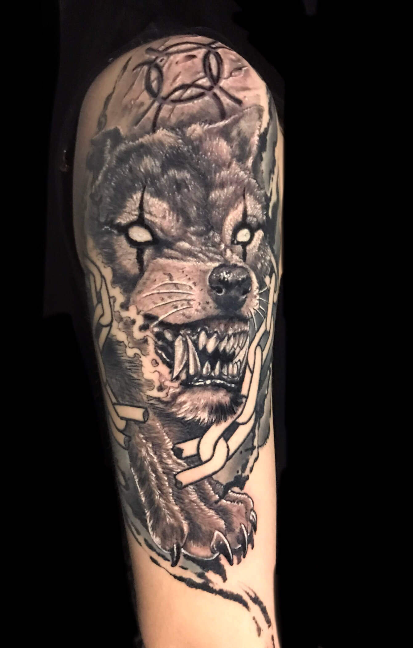 Hombro y brazo tatuado con un lobo